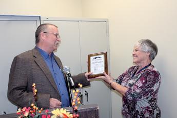 Press photos/Jake Browning - Kathy Kahler presents Alan Durden with a plaque marking his 30 years as cooperative extension director.