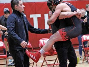 Press photo/Andy Scheidler - Braden Berger jumps into the arms of assistant coach Bill Barrington, while head coach Kyle Barrington also celebrates with the junior. Berger beat Smoky Mountain’s Will Frady for the first time in eight matches.