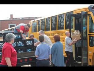 Press photo/Jake Browning - Volunteers at Franklin High School load breakfasts and lunches onto a bus to deliver to local students.