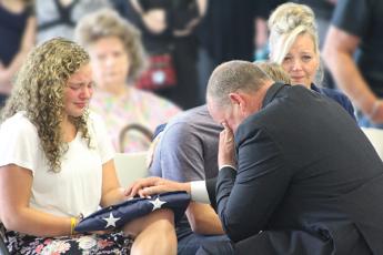 Press photo/Jake Browning - Jeslyn Head, daughter of David Head, is presented with an American flag and Head’s service badge by sheriff Robert Holland during the service.