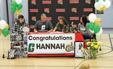 Press Photo/Will Woolever - Senior track and field star Hannah Angel (center right) signs her official offer letter from UNC Charlotte while her brother, Phillip (left); dad, Jeremy; and mom, Jennifer, look on.
