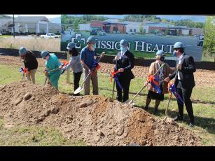 Press photo/Jake Browning - HCA officials turn up the first dirt at the future site of Angel Medical Center at One Center Court. From Left: Becky Dahl, Peggy Ramey, Leslie Vanhook, David Franks, Tim Layman, Karen Gorby, Johnny Mira-Knippel.