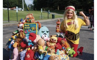 Press photos/Jake Browning - Ten-year-old Annabelle Gunter, dressed as Hulk Hogan, shows off the parade float she made with her mom built around classic 80s toys.