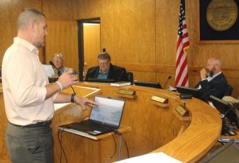 Press photo/Jake Browning - County Manager Derek Roland reviews the new pay scale for county employees at the Oct. 12 meeting.