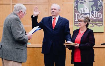 Press photo/Braulio Fonseca - Jack Horton takes the oath of office as mayor of Franklin. Pictured with him are his wife, Lydia, and outgoing Mayor Bob Scott administering the oath of office.