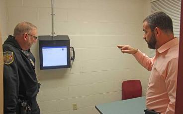 Press photo/Jake Browning - Sergeant Robert Young and jail administrator Dereck Jones demonstrate one of the new videoconferencing kiosks installed with the help of NCIC.