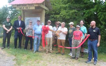 Press photo/Thomas Sherrill - Brent Martin, executive director of the Blue Ridge Bartram Trail Conservancy, cuts the ribbon for the new kiosk and re-route of the Bartram Trail through Franklin during a June 7 ceremony.