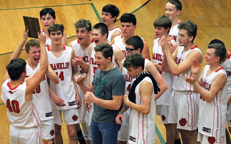 Bradley Stiles (40) holds up the plaque while his teammates react after winning the Mountain Six Conference tournament for junior varsity boys basketball. Franklin went 23-1 this season and dominated Smoky Mountain in the finale. 