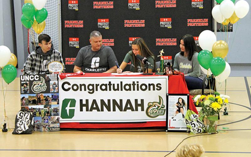 Press Photo/Will Woolever - Senior track and field star Hannah Angel (center right) signs her official offer letter from UNC Charlotte while her brother, Phillip (left); dad, Jeremy; and mom, Jennifer, look on.