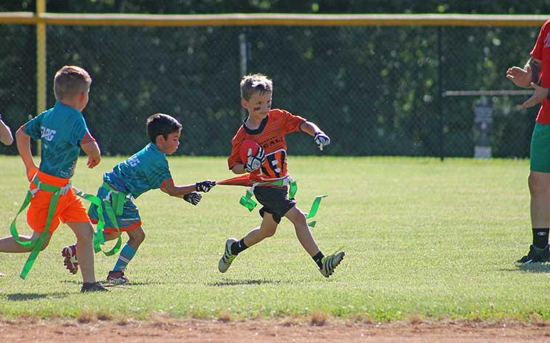 Press photo/Will Woolever A member of the Cincinnati Bengals evades a flag-pull from a Miami Dolphin at the Franklin Flag Football League’s first-ever scrimmage June 7. The league has drawn 180 local boys and girls, ages 5-17. 